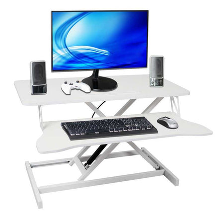 Adjustable standing laptop desk with keyboard tray, shown with monitor, speakers, and accessories. Ergonomic height-adjustable design for workspace comfort.