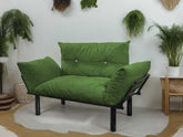 Green futon chair in a room with plants