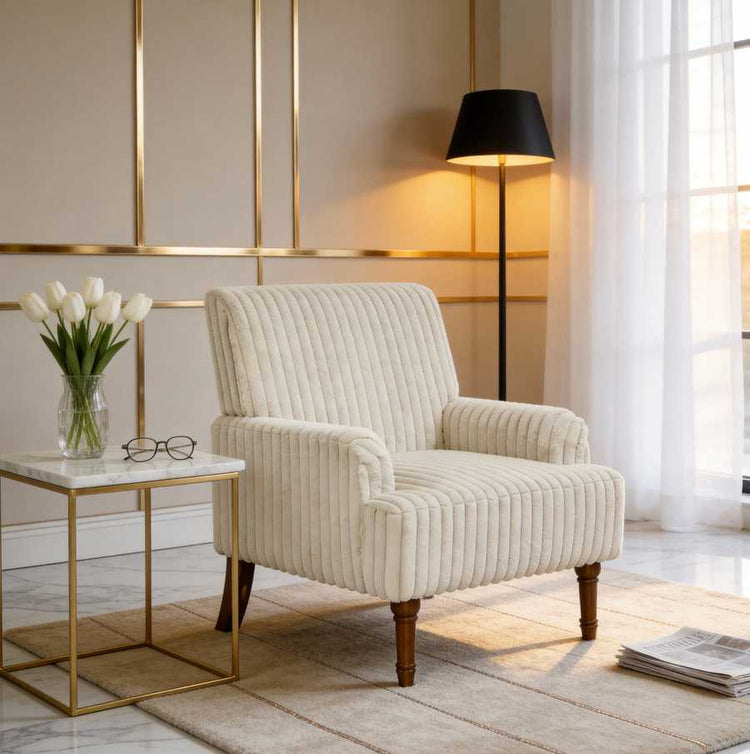 Beige armchair in a stylish living room with a side table and lamp.