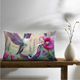 Decorative pillow with floral and bird design on a wooden bench with a vase.