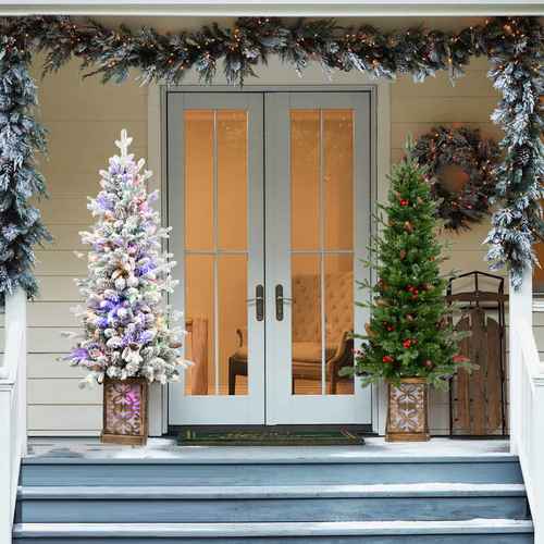 Pre-lit Christmas tree with glitter base beside a front door