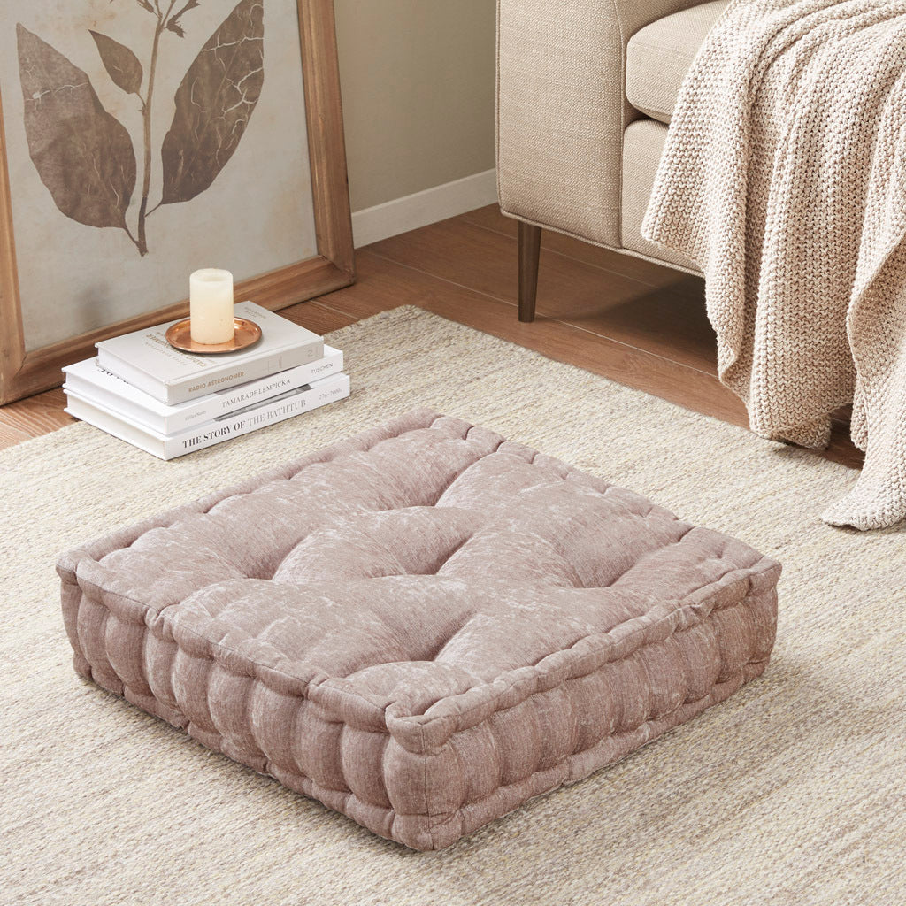 Gray pet bed on a carpeted floor with books and a candle in the background