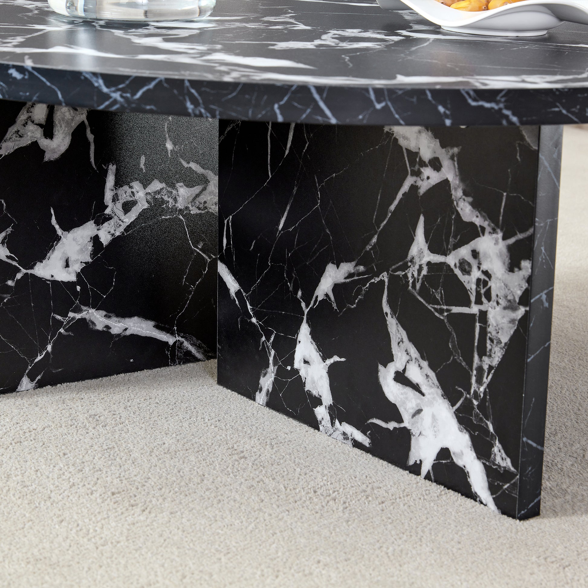 Base detail of black MDF round coffee table with modern minimalism, featuring cross-leg support and marble-like finish.