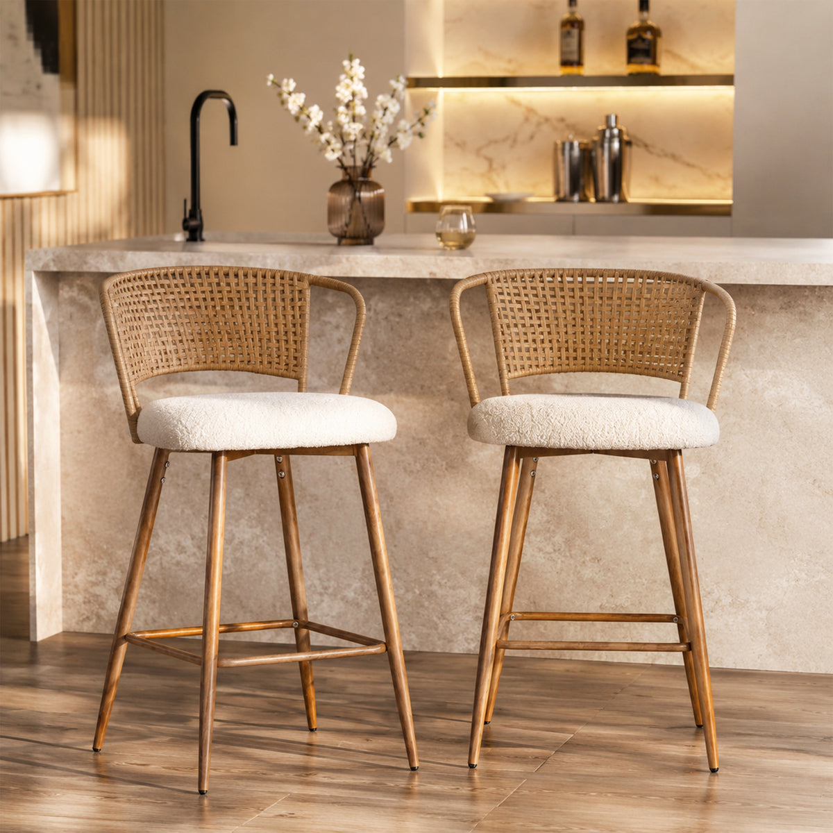 Two modern bar stools with woven cane backs and white bouclé seats, positioned in front of a stone kitchen counter.