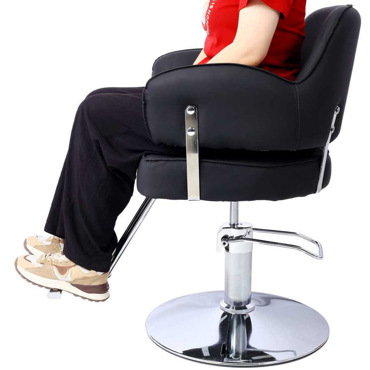 Model seated on Salon Styling Chair for Hair Stylists, showing ergonomic design and adjustable chrome base in use.
