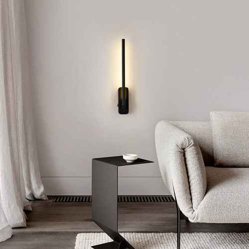 Modern living room with a gray sofa, side table, and wall-mounted lamp.