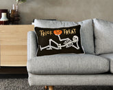 Gray sofa with a Halloween-themed pillow featuring a skeleton and &