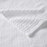 Detailed view of waffle jacquard texture on white cotton bath towel, part of the 6 piece quick drying towel set with antimicrobial treatment.