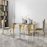 Oval dining table with black glass top and gold base shown with four gray and gold chairs in a luxury dining room setup.