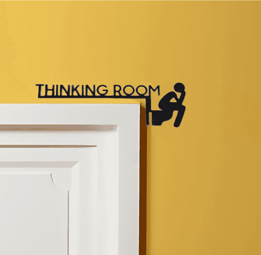 Modern novelty wall art sign 'Thinking Room' in marble style metal, displayed above a white door on a yellow wall.