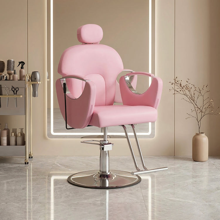 A pink salon barber chair with a chrome hydraulic base, shown in a modern, softly lit beauty salon interior.