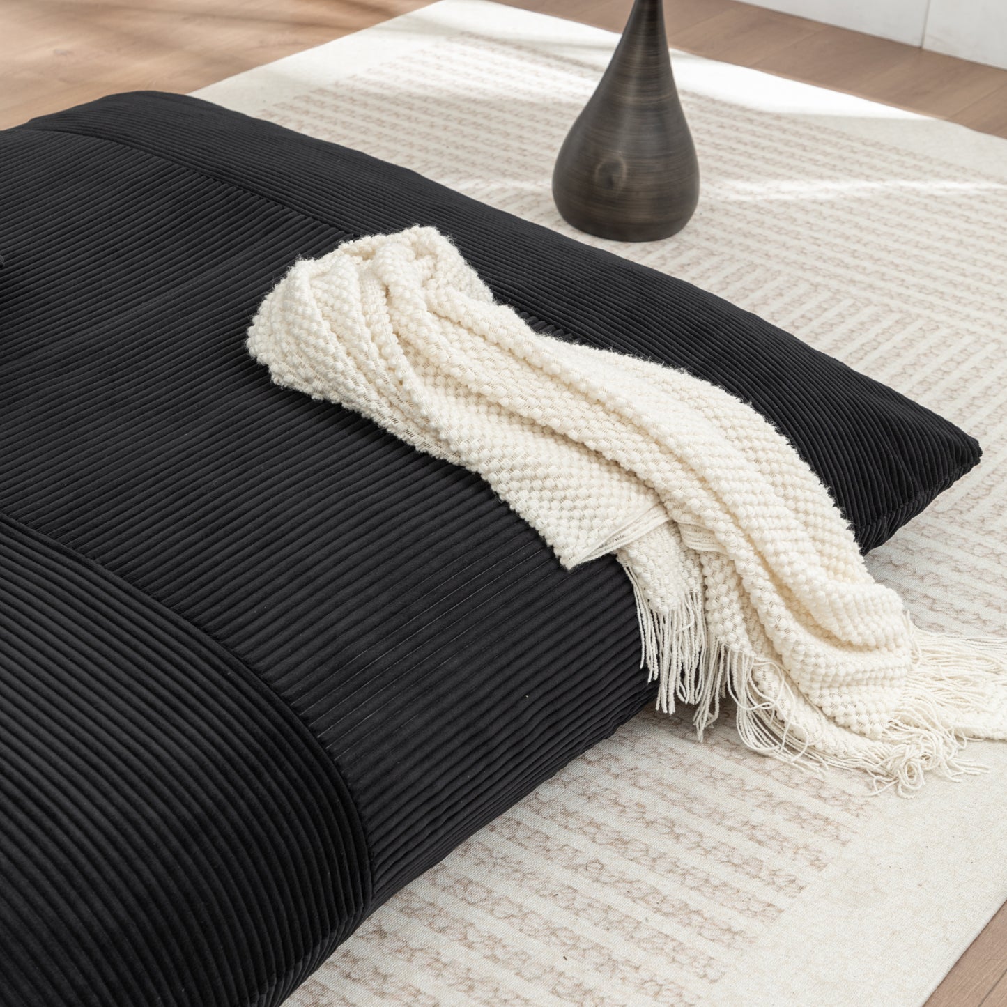 Close-up of Corduroy Bean Bag Chair with cream throw, showcasing soft ribbed texture and cozy lounging appeal.