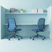 Two blue office chairs in a small office space with a white desk and shelves.