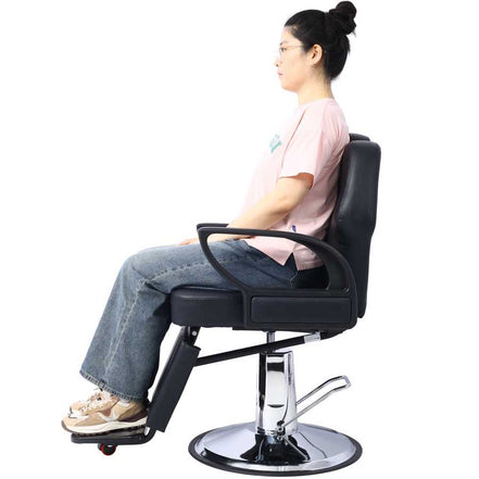 Barber Chair - Heavy Duty Hydraulic with PU leather and adjustable backrest shown upright with person seated. Ideal for salon professionals.