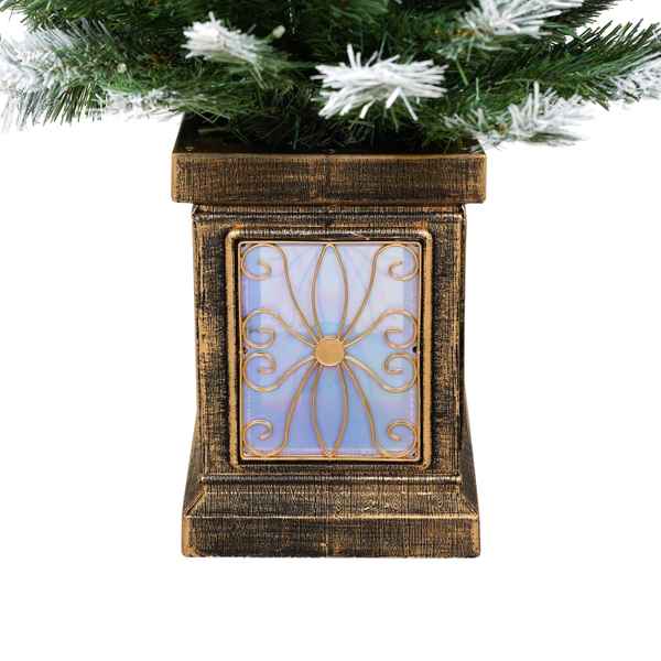 Decorative lantern with floral design under a Christmas tree