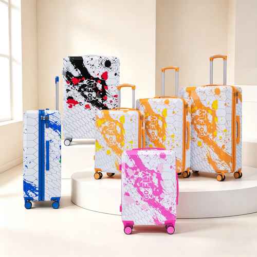 Colorful set of spinner luggage suitcases in various colors including pink, blue, and orange with matching printed designs, suitable for travel.