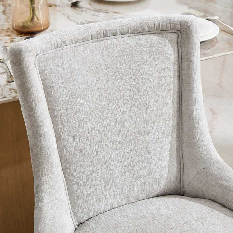 Close-up of a gray upholstered chair with a blurred background
