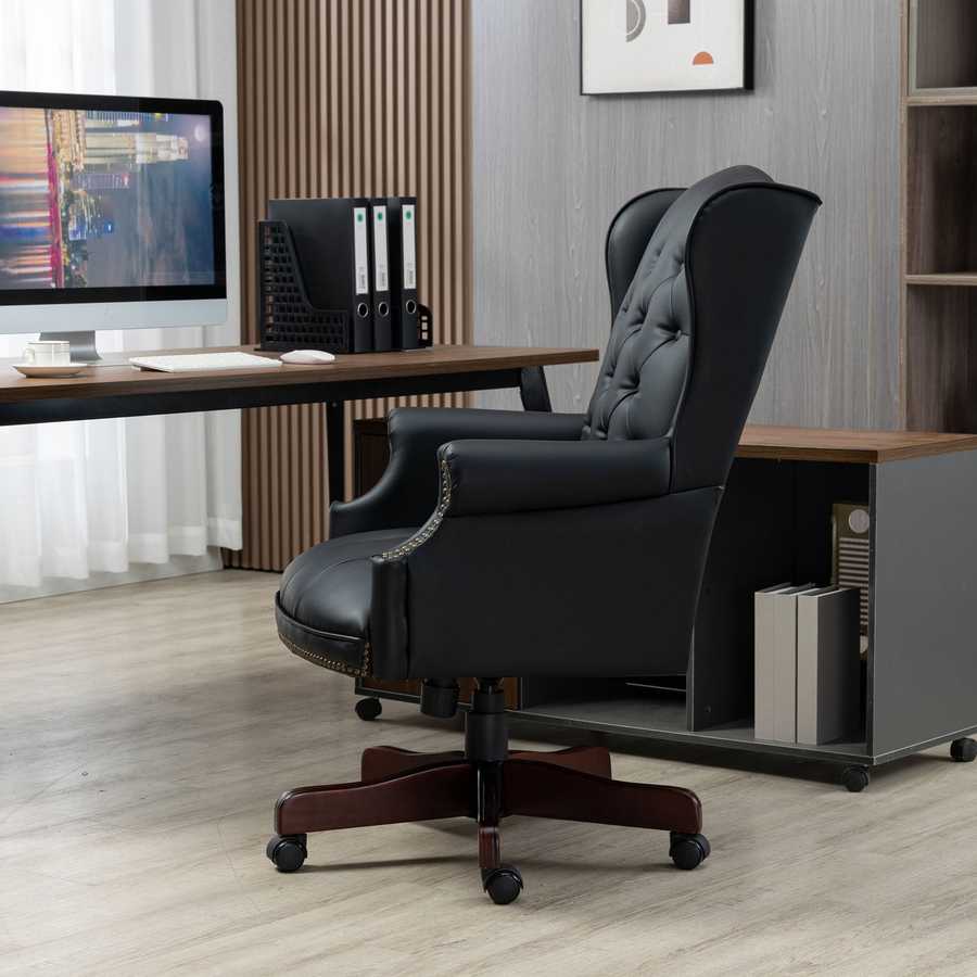 Black office chair in front of a desk with a computer setup in an office setting.