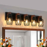 Four industrial-style wall lights above a mirror with decorative flowers on either side.