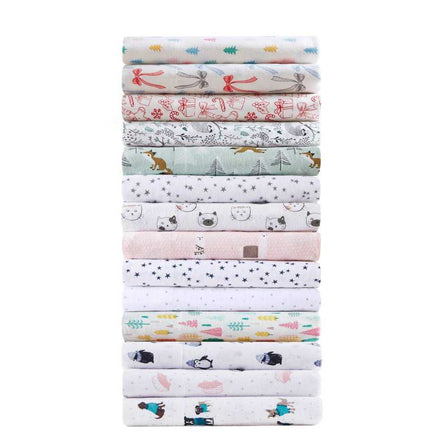 Stack of various printed cotton flannel sheet sets including Happy Bows, showcasing multiple design options for bedding.