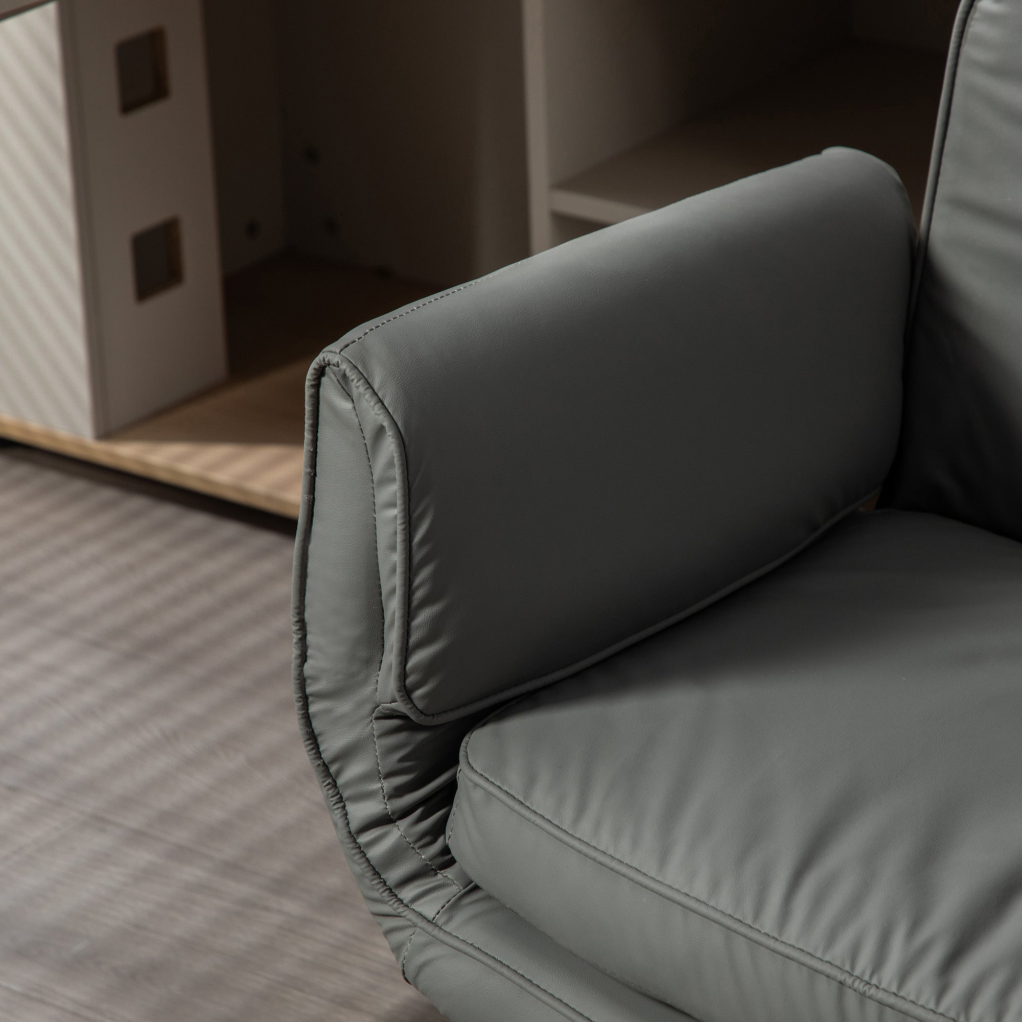 Gray cushioned chair with a blurred background