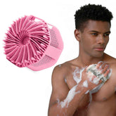 Man using a pink scrubber on his arm with a close-up of the scrubber on a white background.