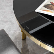 Close-up of black tempered glass tabletop on oval dining table, highlighting smooth finish and elegant design.