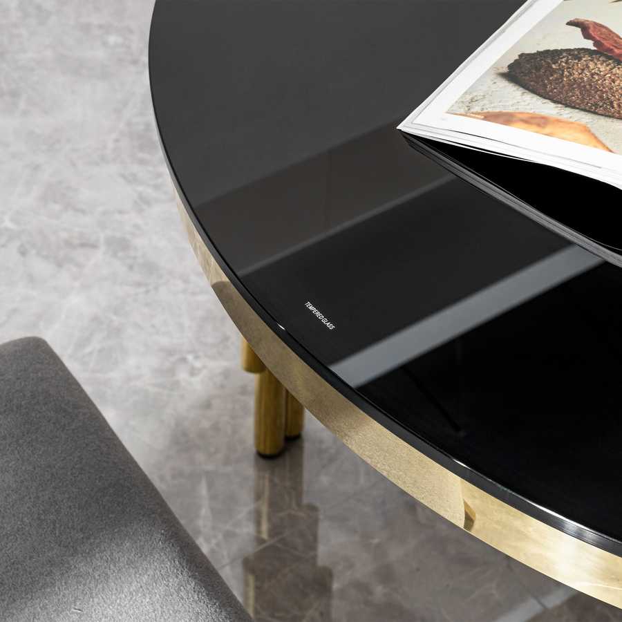 Close-up of black tempered glass tabletop on oval dining table, highlighting smooth finish and elegant design.