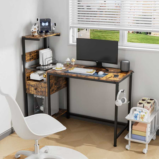 Computer desk with power outlet and reversible shelves in a home office setup, featuring rustic wood finish, monitor, and storage compartments.