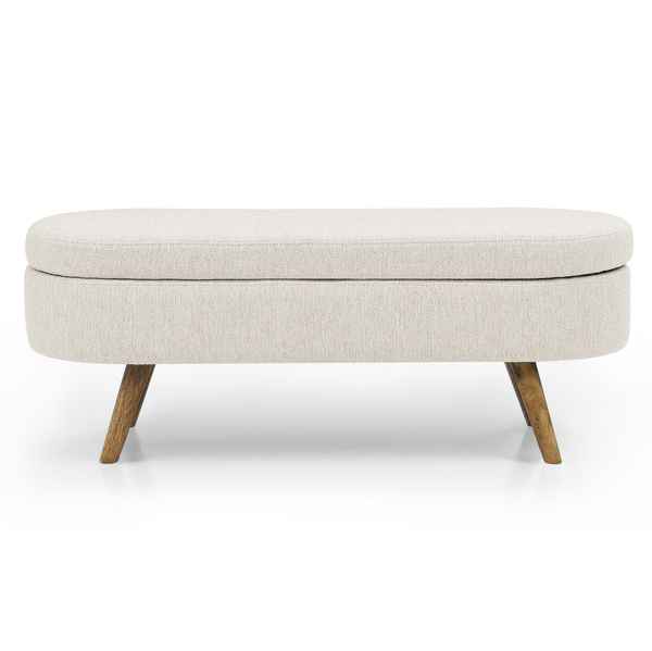 An upholstered storage bench with a rounded rectangular shape, featuring a light beige textured fabric cushion on a frame with tapered wooden legs, shown against a plain white background.