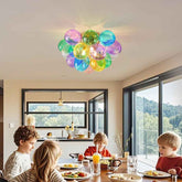 Children sitting at a dining table with a colorful balloon-like ceiling light fixture.
