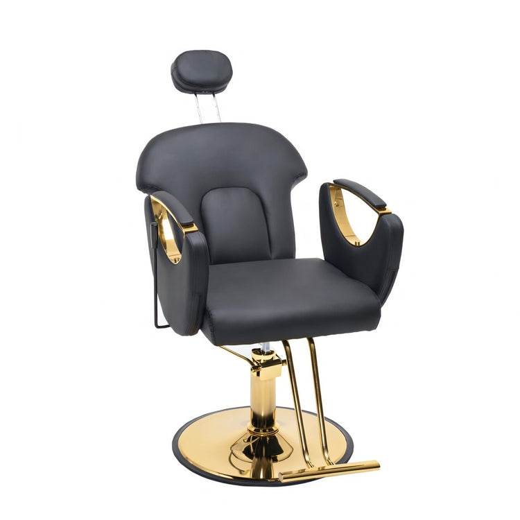 A modern barber or salon chair with black faux leather upholstery and polished gold metal accents, including the base, armrests, and headrest support, shown on a plain white background.