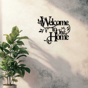 Welcome to Our Home floral wall art in black iron mounted on a textured wall, adding charm to home and garden entryway decor.
