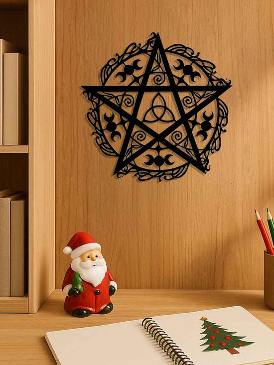 Decorative pentagram wall decal on a wooden wall with a Santa Claus figurine and notebook below.
