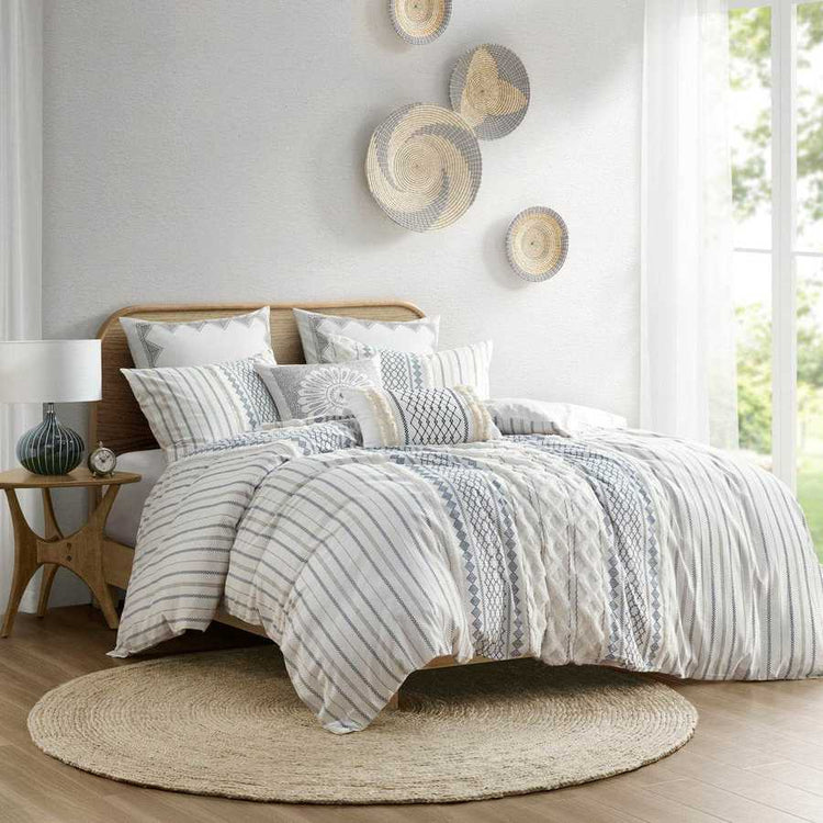 Bedroom with striped bedding and decorative baskets on the wall