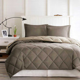Quilted comforter set on a bed in a bedroom setting with a lamp and plant.