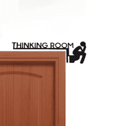 Humorous bathroom wall art metal sign with 'Thinking Room' text and figure on toilet, mounted on a wooden door frame.