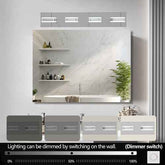 A wall-mounted bathroom mirror with integrated LED lighting and a dimmer switch control shown below. The mirror reflects a modern white marble-look vanity with shelves and a plant.