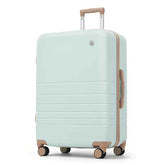 A hard-shell spinner suitcase in a pale mint green color with light brown accents on the telescoping handle, side handle, zipper trim, and wheel caps, shown on a plain white background.