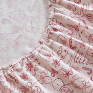 Holiday Doodles - Twin XL Cotton Flannel Sheet Set fitted sheet detail showing elastic edge and holiday-themed red prints on soft flannel.