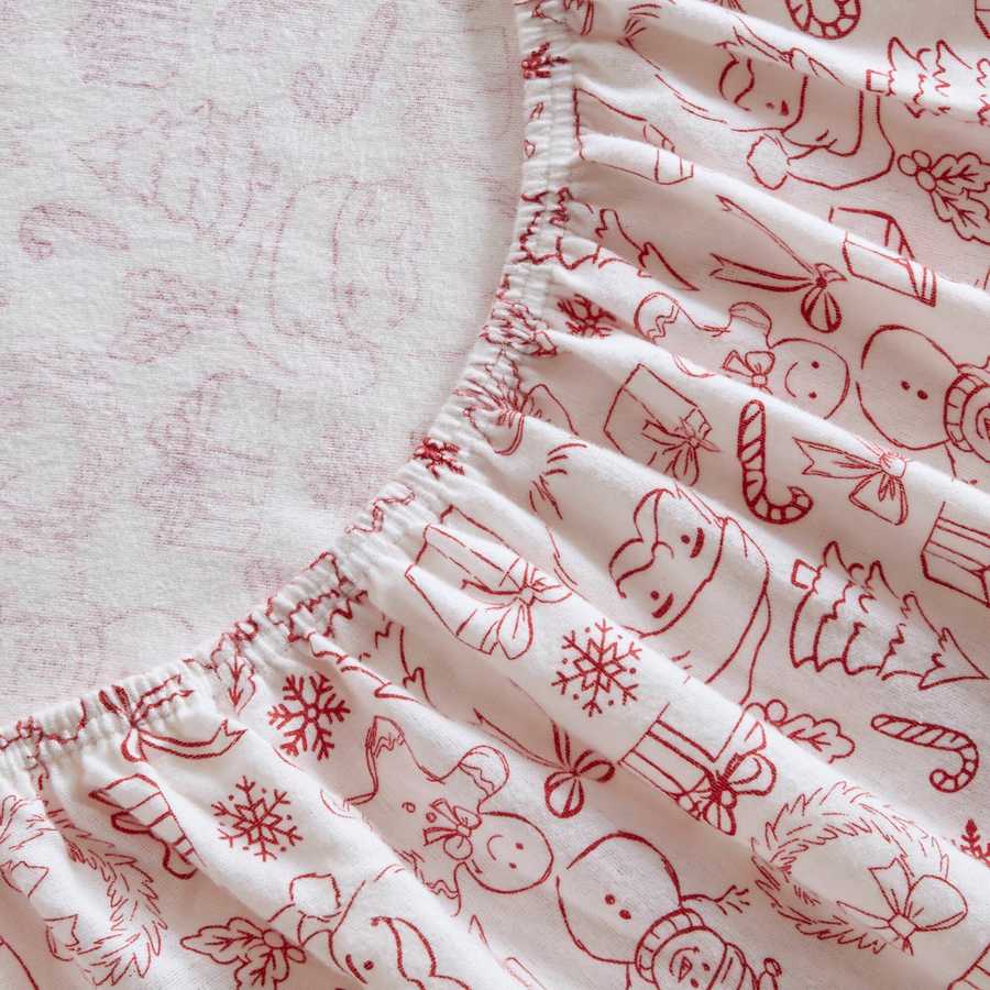 Holiday Doodles - Twin XL Cotton Flannel Sheet Set fitted sheet detail showing elastic edge and holiday-themed red prints on soft flannel.