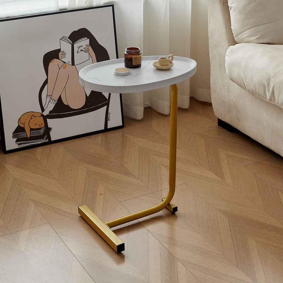 Small round white table with gold legs in a living room setting.