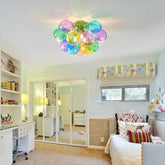 Colorful balloon light fixture in a room with a bed, desk, and bookshelf.