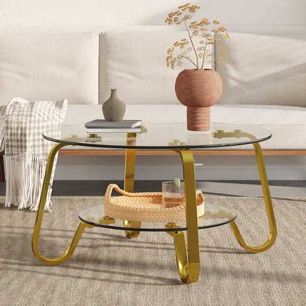 Glass coffee table with vintage gold metal frame and two-tier design, complementing a minimalist white sofa.