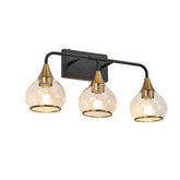 Three-light wall sconce with gold fixtures and clear glass shades on a white background