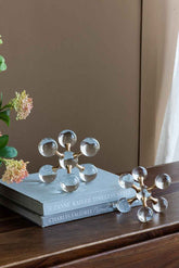 Decorative crystal sculpture on a stack of books with a neutral background