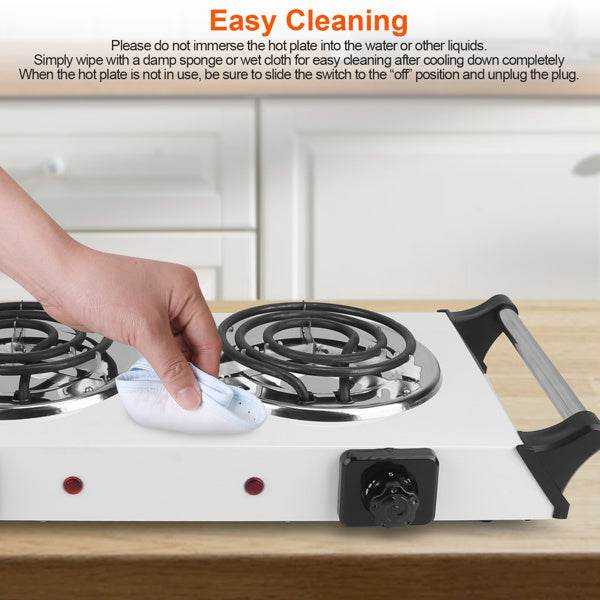 Person cleaning electric stove burners with damp cloth