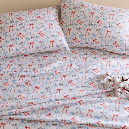 Happy Bows Twin XL Cotton Flannel Sheet Set with red, blue, and gray bow prints on a white background, soft and cozy for year-round comfort.
