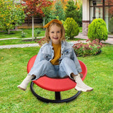 Child sitting on a red chair in a garden