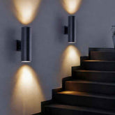 Modern black wall lights on a gray wall with steps below